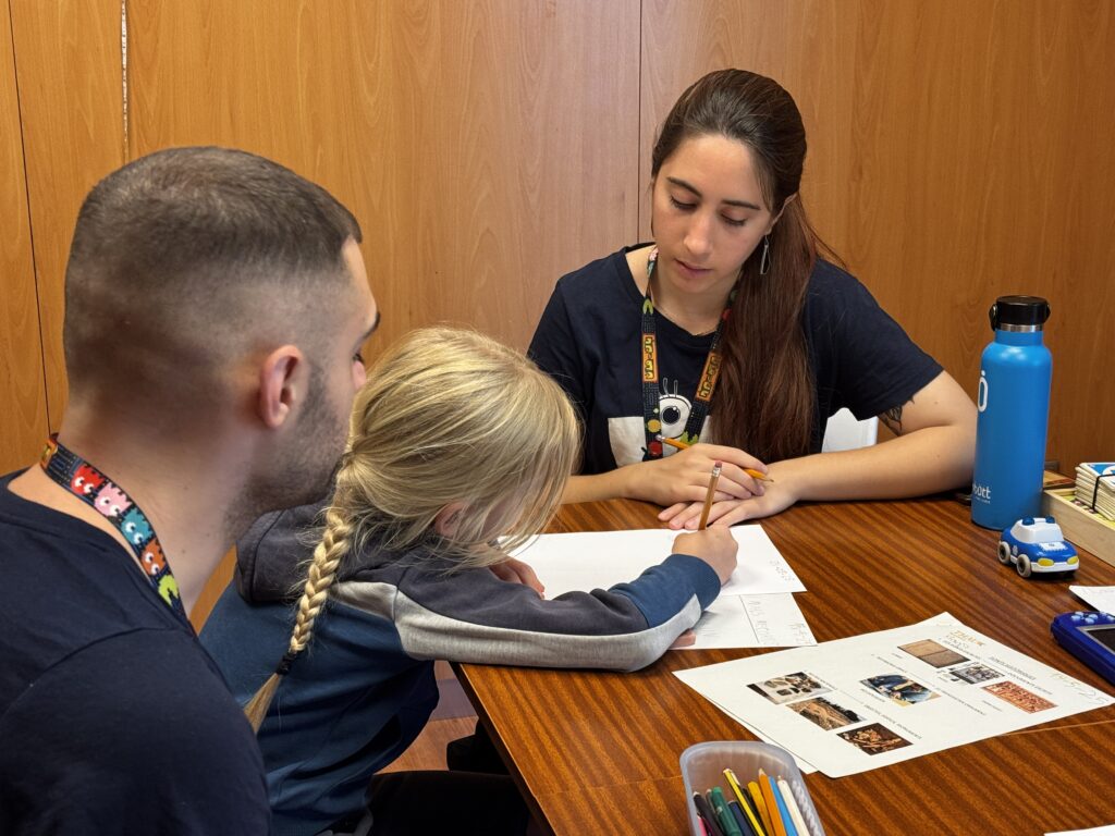 Psicóloga infantil acompañando a un niño durante una sesión educativa.